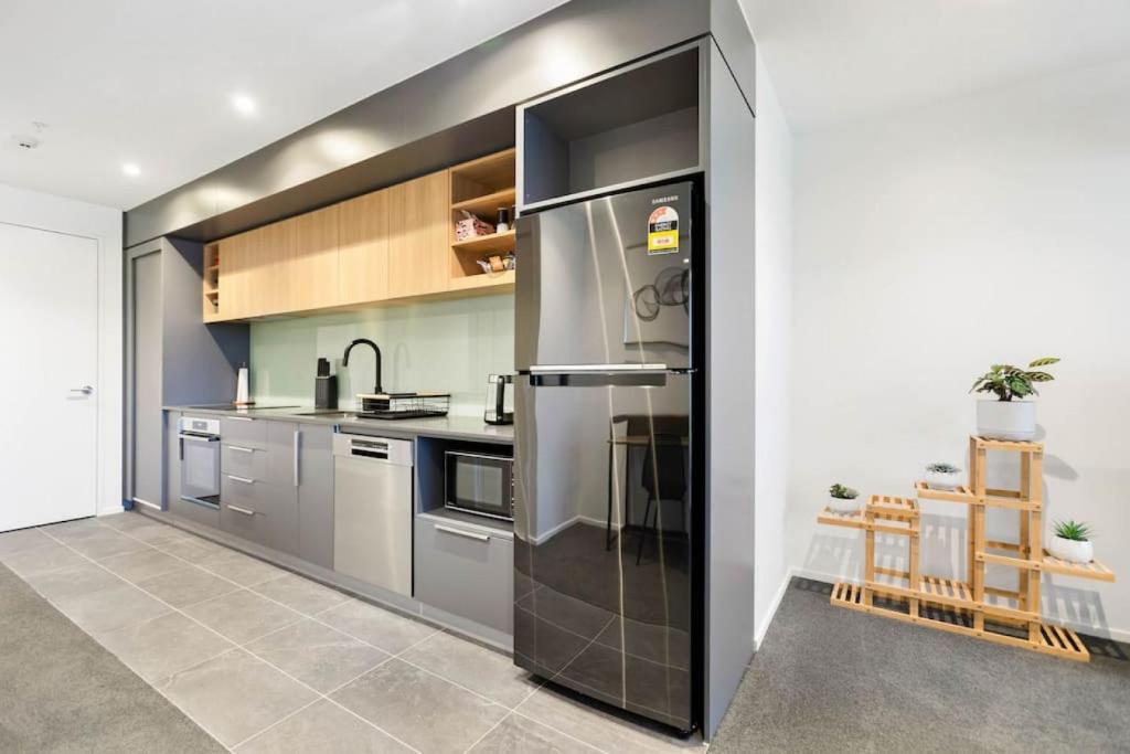 uma cozinha com um grande frigorífico de aço inoxidável em Valley View Apartment with Mountain Views & Wi-Fi em Auckland