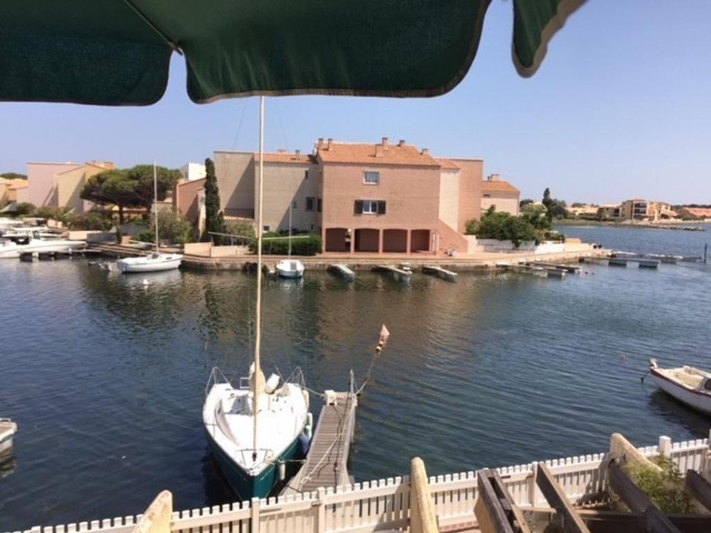 un bateau est amarré à un quai dans l'eau dans l'établissement Studio 2 Pers, Piscine, Parking, Animaux admis - FR-1-81-245, au Barcarès