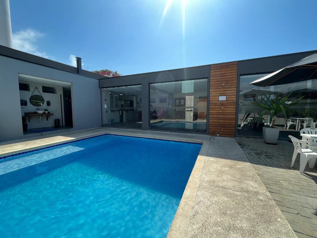 - une piscine dans l'arrière-cour d'une maison dans l'établissement Cadiz Pousada e Lazer, à Bertioga
