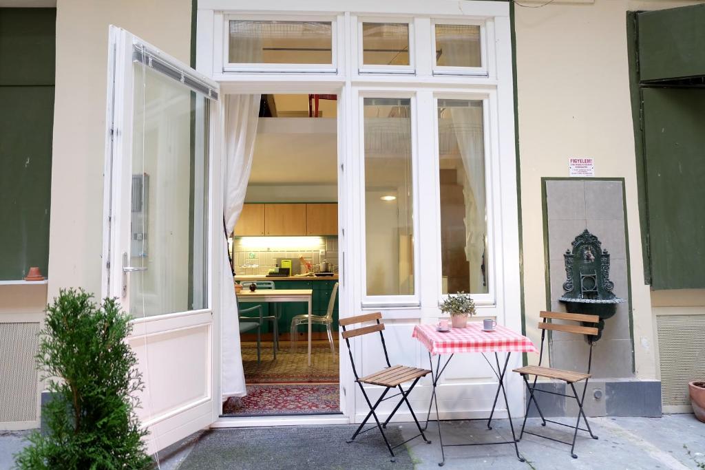 a patio with a table and chairs in front of a building at Art & Design Studios in Budapest