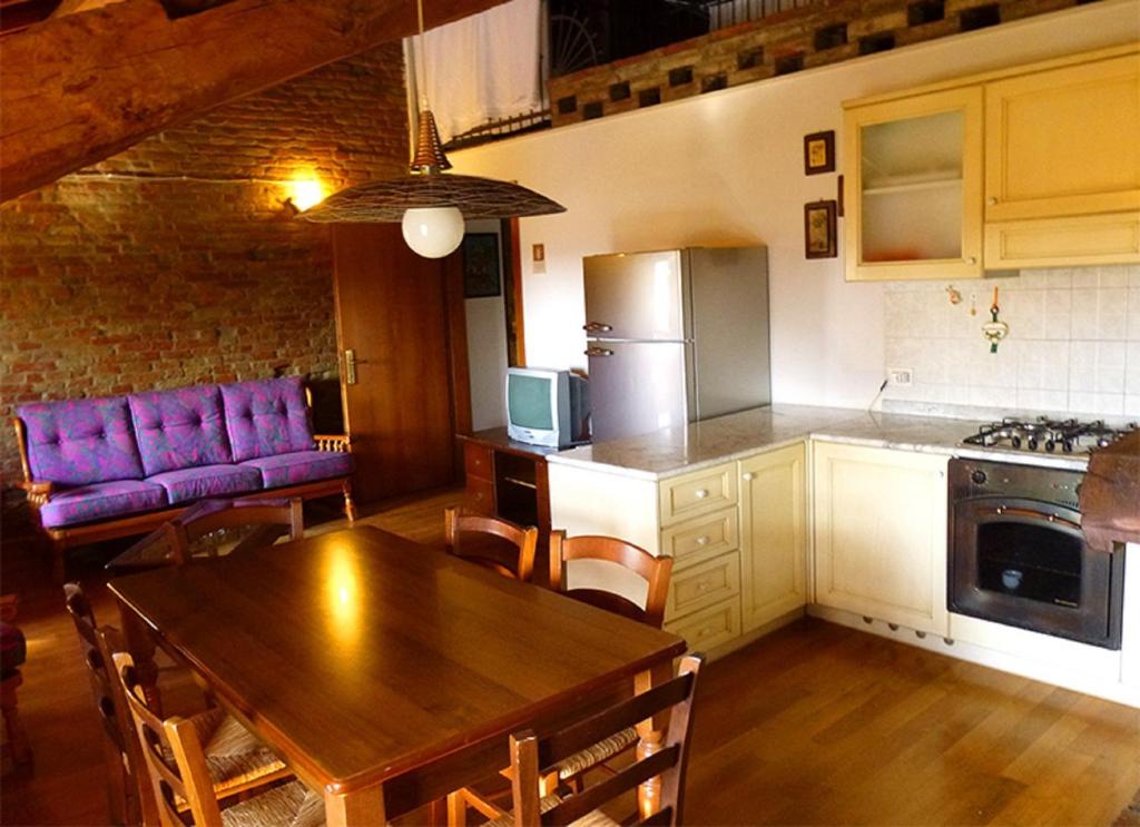 cocina y comedor con mesa de madera en La Tomina, en Mirandola