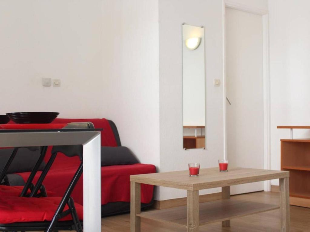 a living room with a red couch and a table at Appartement La Rochelle, 2 pièces, 4 personnes - FR-1-246-273 in La Rochelle