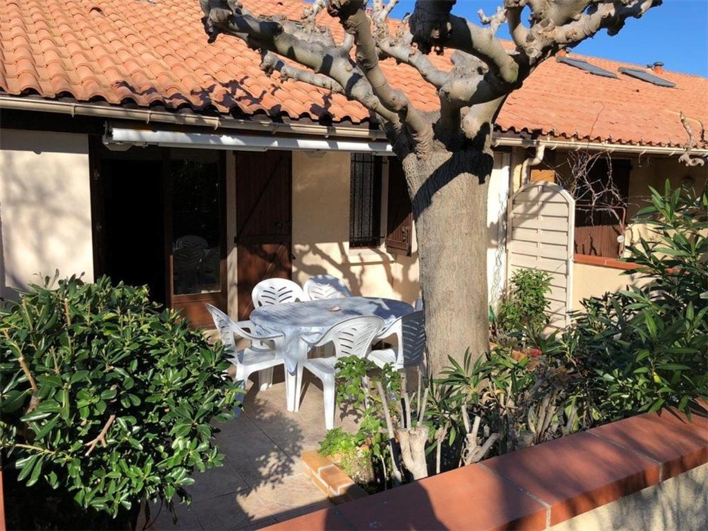 un patio avec une table et des chaises devant une maison dans l'établissement Villa T2 Mezzanine Climatisée, 6 Pers, Terrasse, à 350m de la Plage - Port Leucate - FR-1-81-445, à Port-Leucate