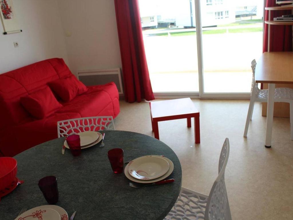 a living room with a table and a red couch at Appartement La Rochelle, 2 pièces, 4 personnes - FR-1-246-286 in La Rochelle