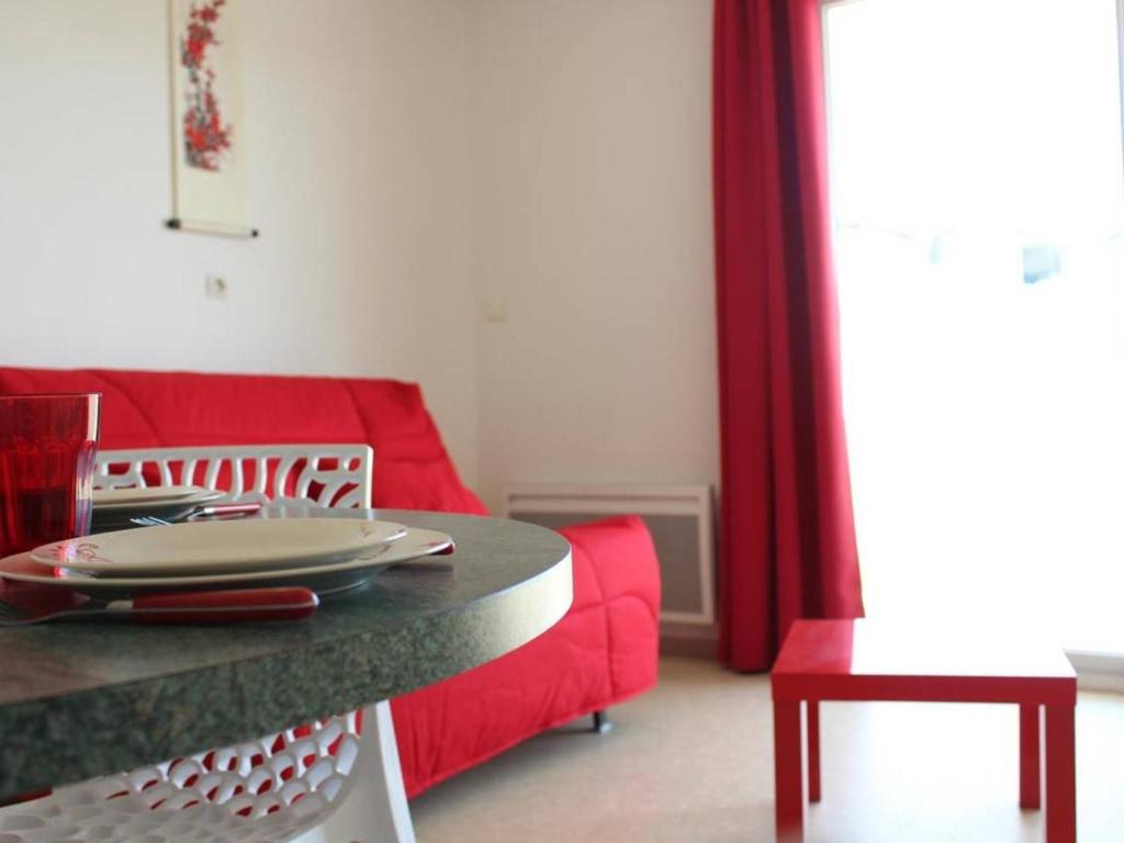 a living room with a red couch and a table at Appartement La Rochelle, 2 pièces, 4 personnes - FR-1-246-286 in La Rochelle