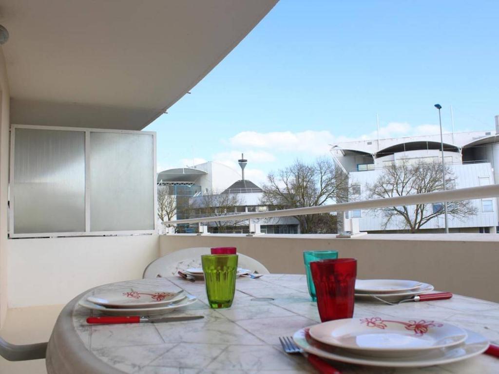 a table with plates and glasses on a balcony at Appartement La Rochelle, 2 pièces, 4 personnes - FR-1-246-286 in La Rochelle