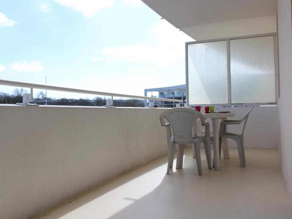 a balcony with two chairs and a table on a roof at Appartement La Rochelle, 2 pièces, 4 personnes - FR-1-246-286 in La Rochelle