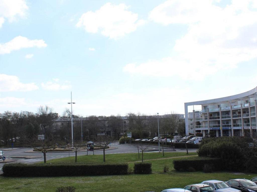 a parking lot in front of a large building at Appartement La Rochelle, 2 pièces, 4 personnes - FR-1-246-286 in La Rochelle