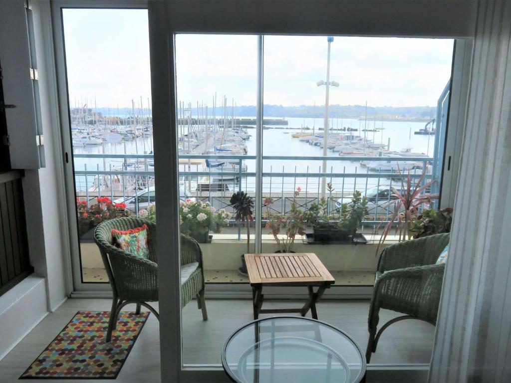 un balcon avec une table et des chaises et une vue sur un port dans l'établissement Appartement avec loggia et balcon à Perros-Guirec - FR-1-368-295, à Perros-Guirec