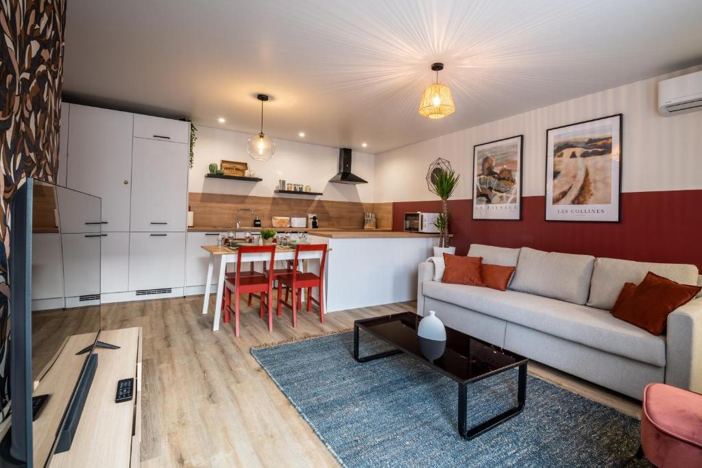 ein Wohnzimmer und eine Küche mit einem Sofa und einem Tisch in der Unterkunft Jolie Maison de ville proche centre-ville in Avignon