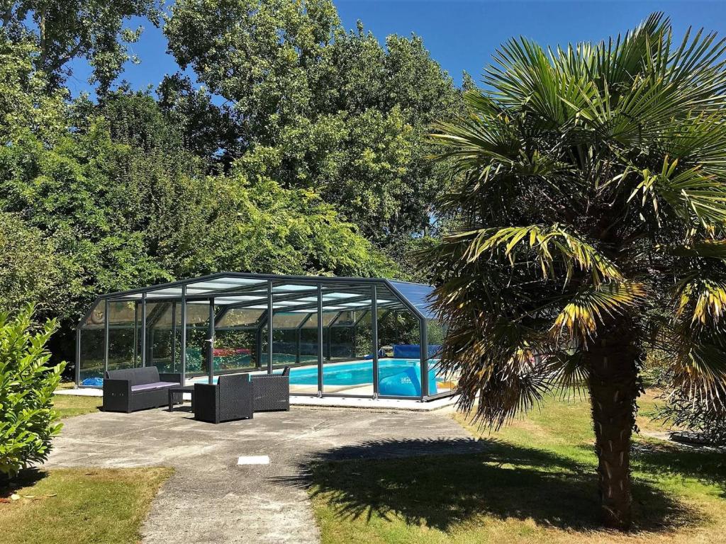un pavillon avec une piscine et un palmier dans l'établissement Villa plain-pied avec piscine privée, jardin et WIFI - Proche Trégastel et Perros-Guirec - FR-1-368-86, à Pleumeur-Bodou