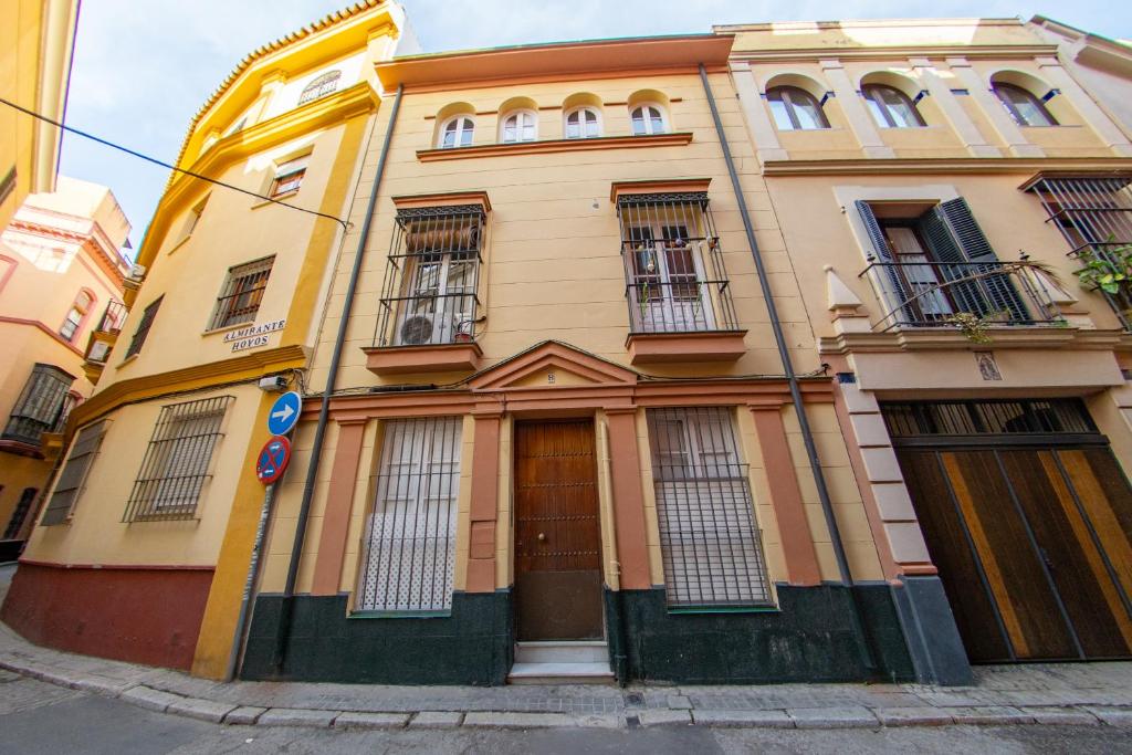 a yellow building with windows and doors on a street at MI RETIRO SEVILLANO in Seville