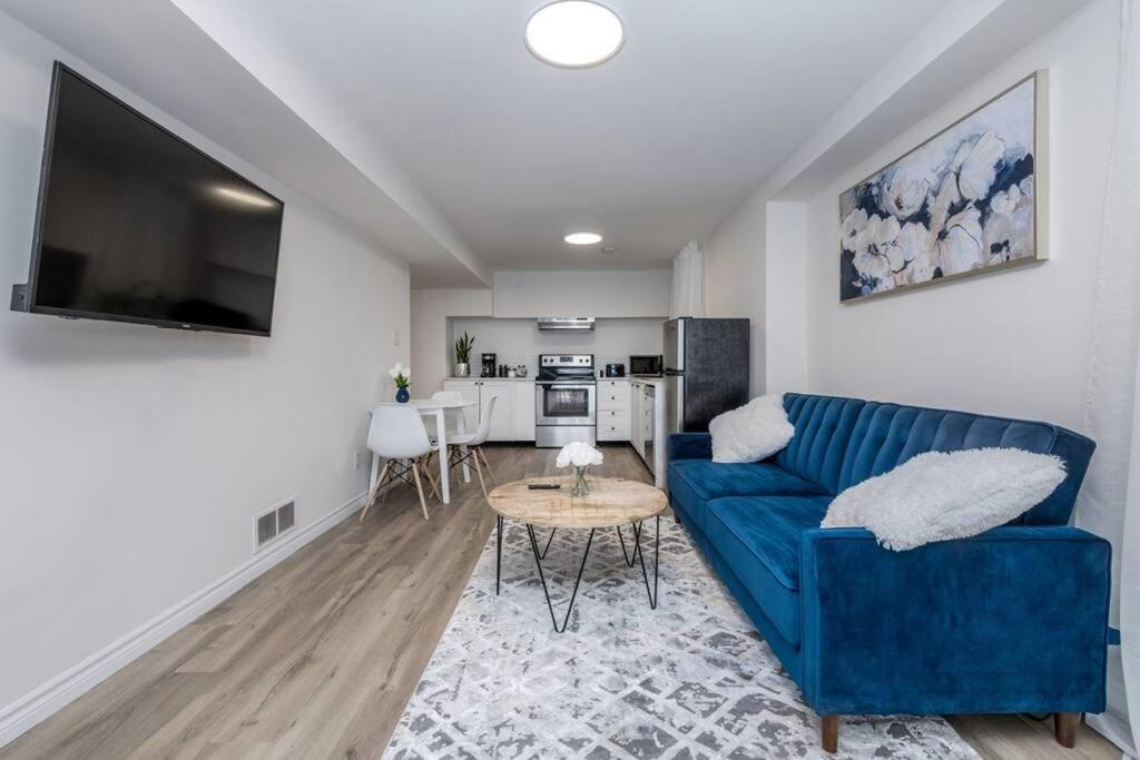 een woonkamer met een blauwe bank en een tafel bij *Modern & Cozy* Basement 1 Bdrm W/Fast Internet & Smart TV in Barrie