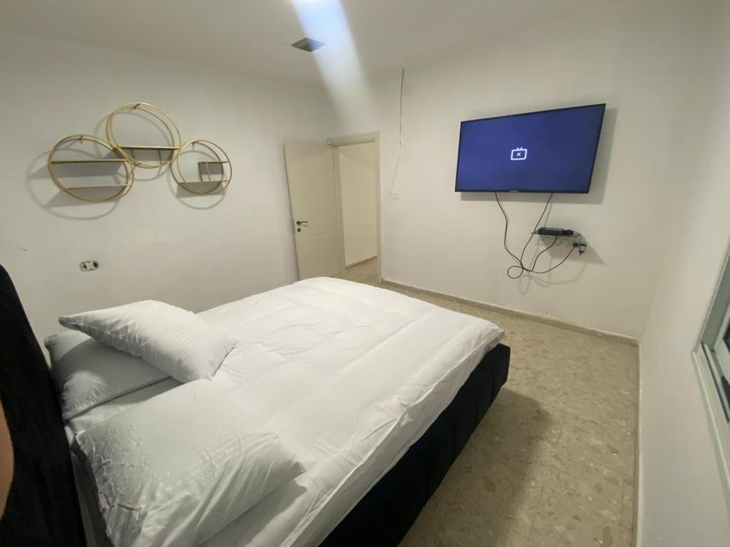 um quarto com uma cama e uma televisão na parede em Vila kasa vali em Zekharya
