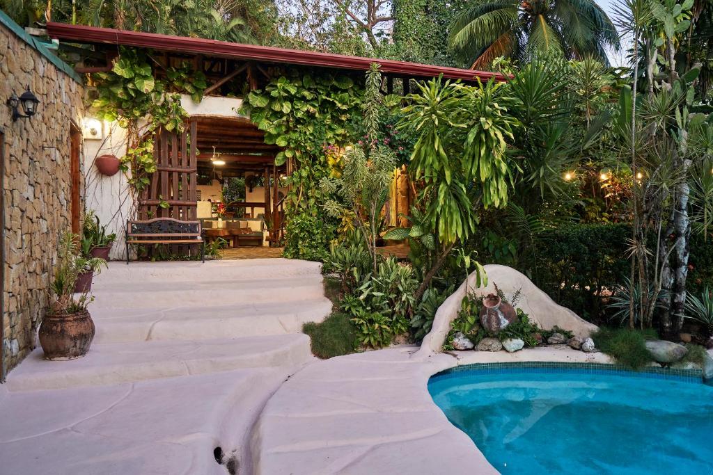 a backyard with a swimming pool and a house at Havana Lodge in Mal País