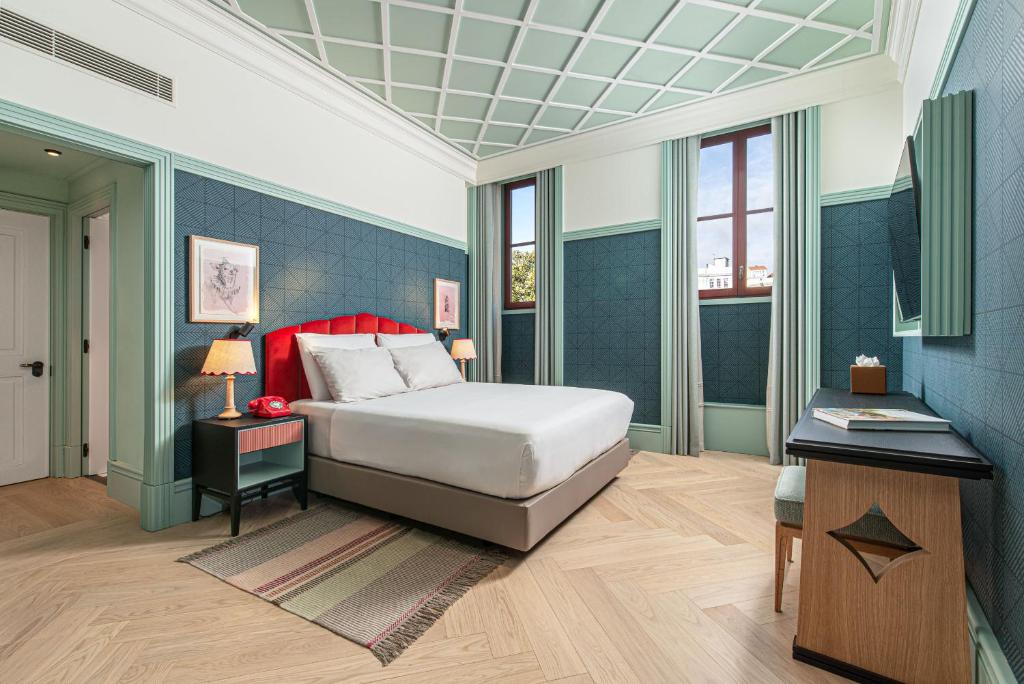 een slaapkamer met een bed en een tafel met een bureau bij The Editory Boulevard Aliados Hotel - Preferred Hotels in Porto