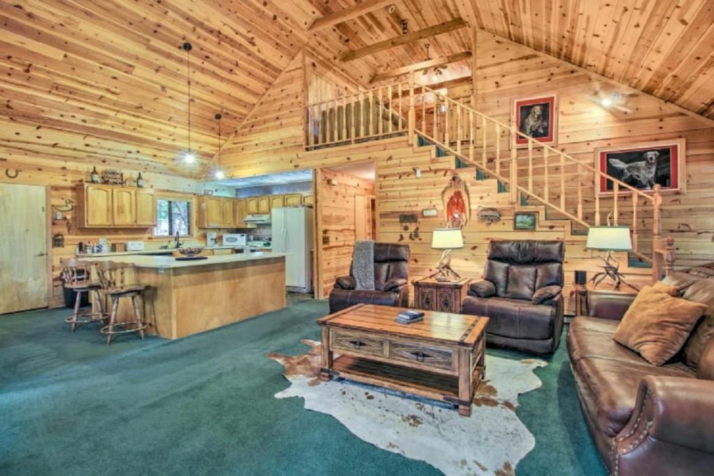 ein Wohnzimmer mit einer Treppe in einem Blockhaus in der Unterkunft The Forest View Lodge in Pinetop-Lakeside