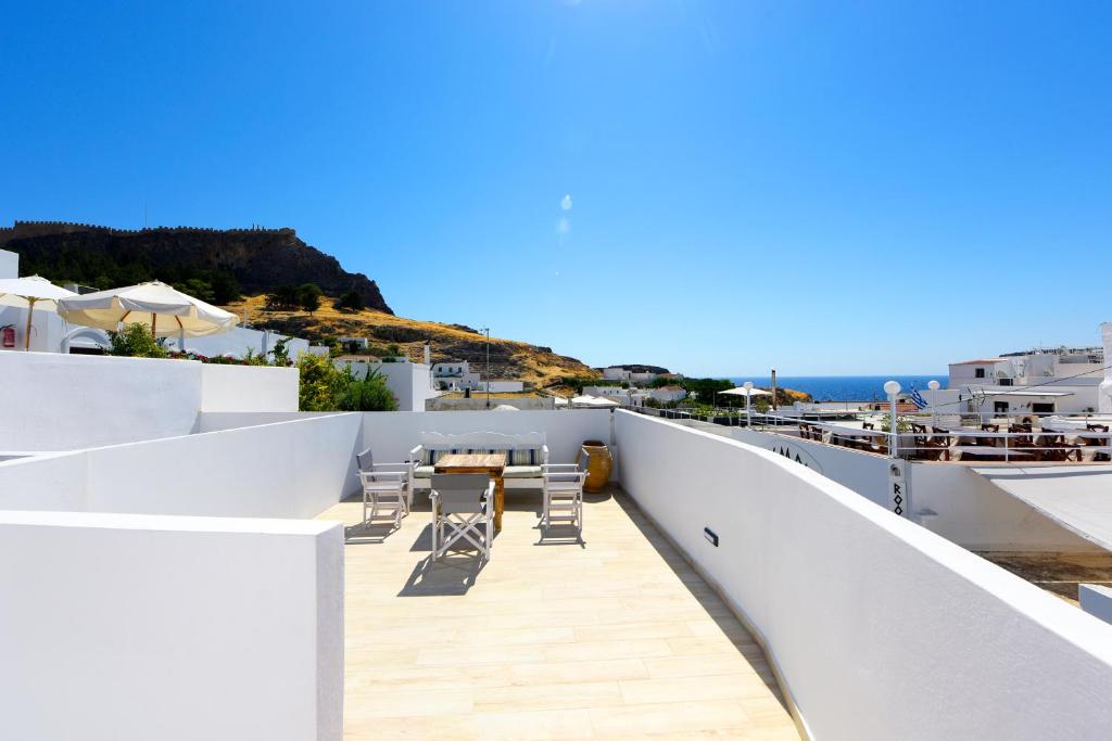 a balcony of a house with a table and chairs at Pera houses 2-bedroom in the center of Lindos in Líndos