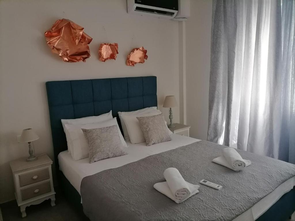 een slaapkamer met een bed met twee handdoeken erop bij Petrani Suite 1 in Néa Péramos