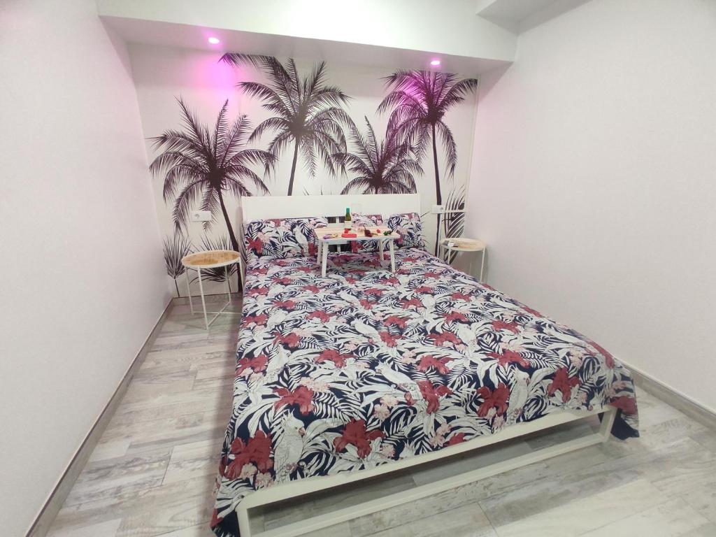 Schlafzimmer mit einem Bett mit Palmenmilch in der Unterkunft Sweet Apt Charco by flamingo house in Arrecife