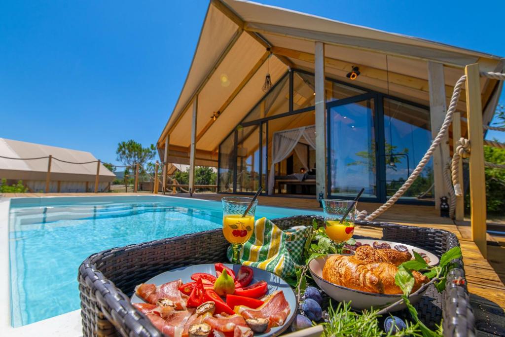 una bandeja de comida en una mesa junto a una piscina en Floria Glamping Garden, en Labin