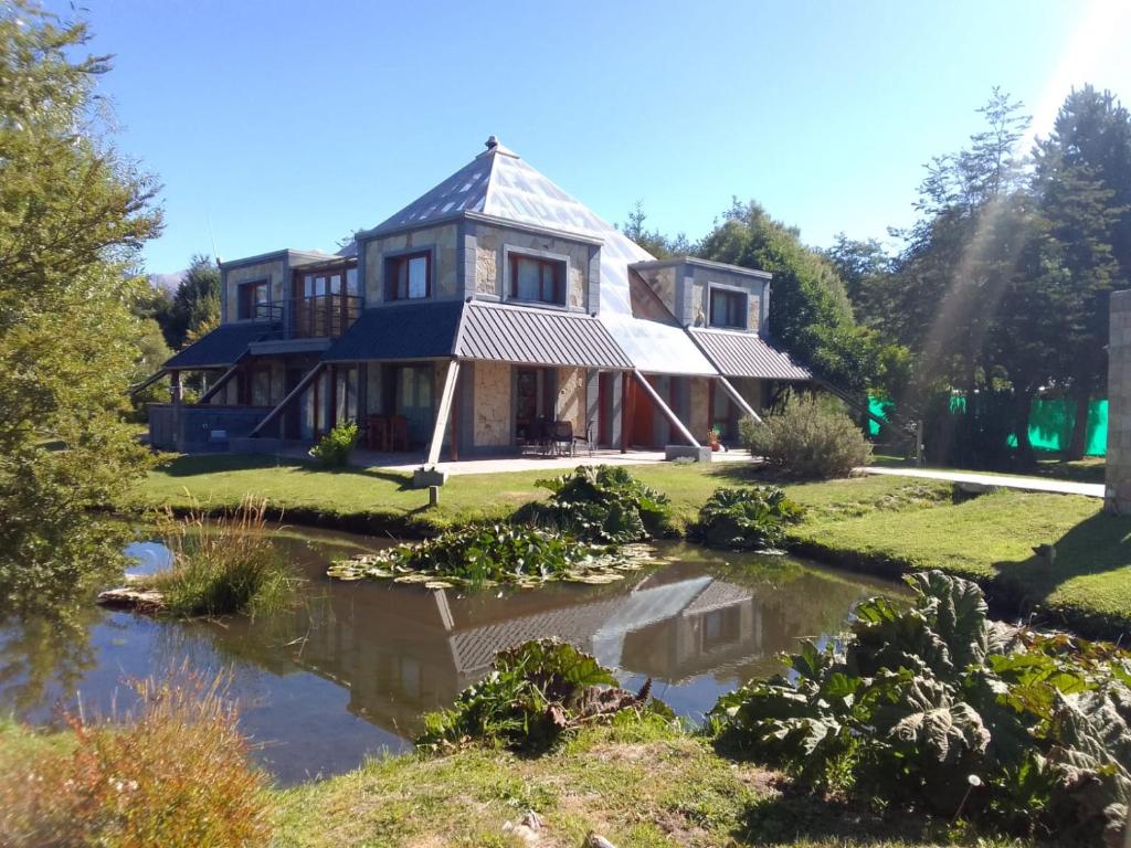 una casa con un estanque delante de ella en La Pirámide en San Carlos de Bariloche