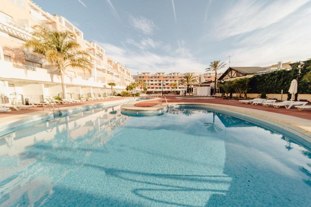 una gran piscina en un complejo con sillas y edificios en Complejo Turístico Marina Rey, en Vera