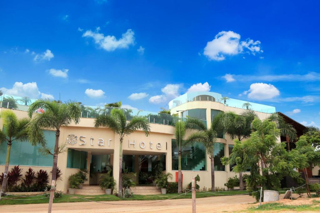 um hotel de estrelas com palmeiras em frente em Star Hotel em Jericoacoara