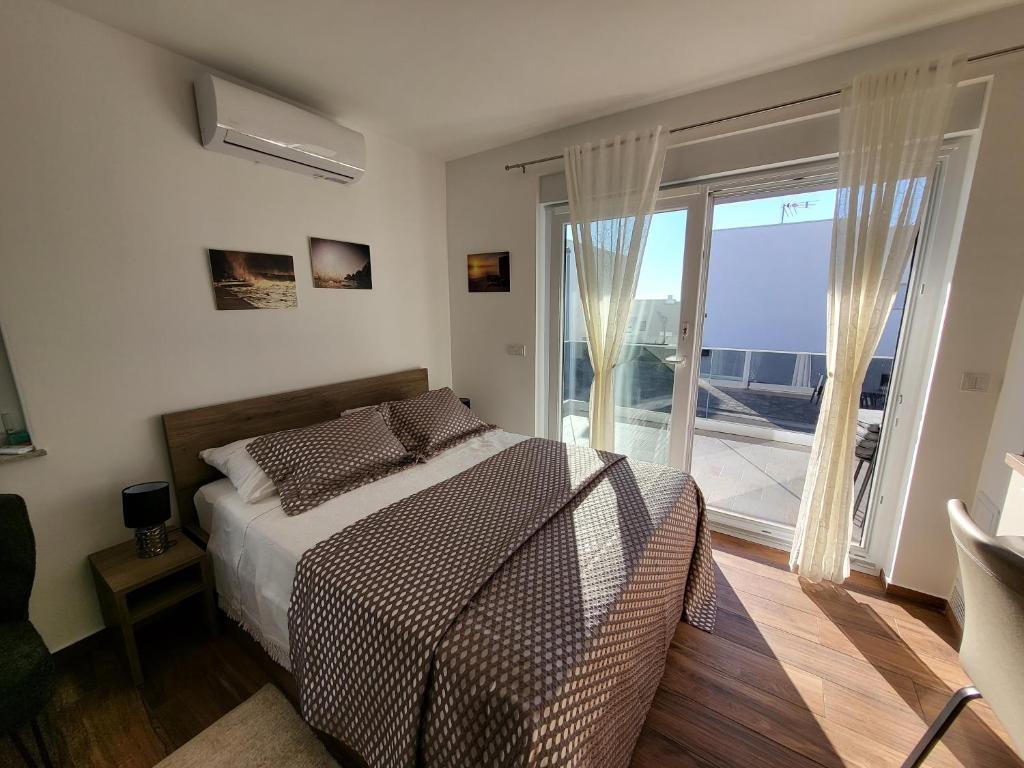 a bedroom with a bed and a large window at Studio apartman Pegi in Šimuni