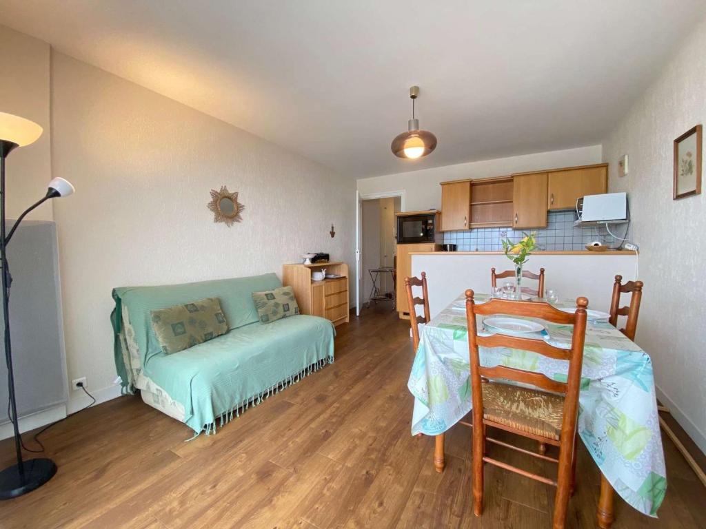 Cette chambre comprend un lit, une table et une cuisine. dans l'établissement Appartement T2 Cabine 6 pers avec balcon, à deux pas de la mer et des commerces - La Baule - FR-1-245-136, à La Baule