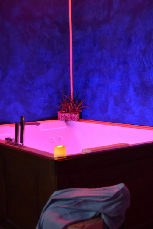 Boutique Relais Villa Sofia في غايولي إن كيانتي: حمام مع حوض استحمام مع إضاءة أرجوانية