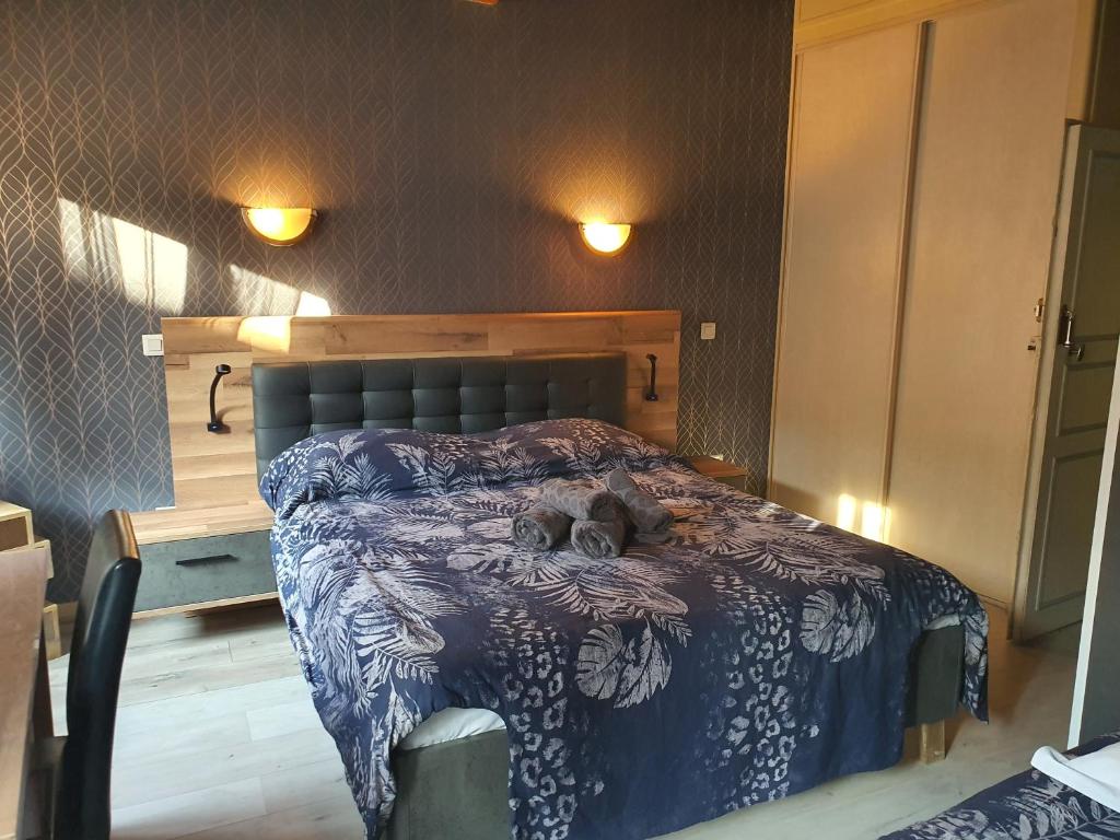 eine Katze, die in einem Schlafzimmer auf einem Bett liegt in der Unterkunft Hotel du Centre in Gueugnon