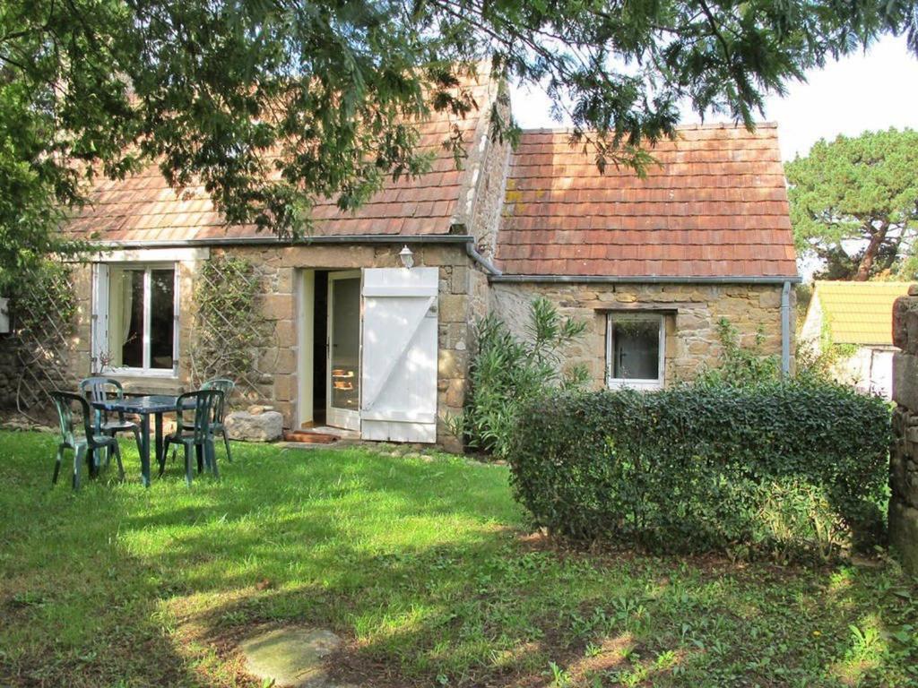 une maison avec une table et des chaises dans la cour dans l'établissement Maison de pêcheur 2** à Trégastel, proche mer avec Wifi, jardin et parking privé - FR-1-542-17, à Trégastel