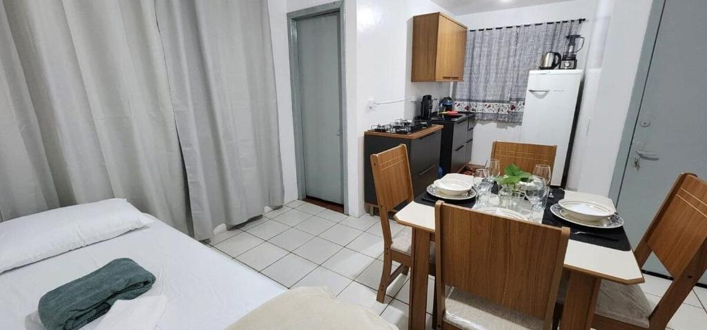 a kitchen with a table and chairs and a dining room at Apartamento PRATICO in Cascavel
