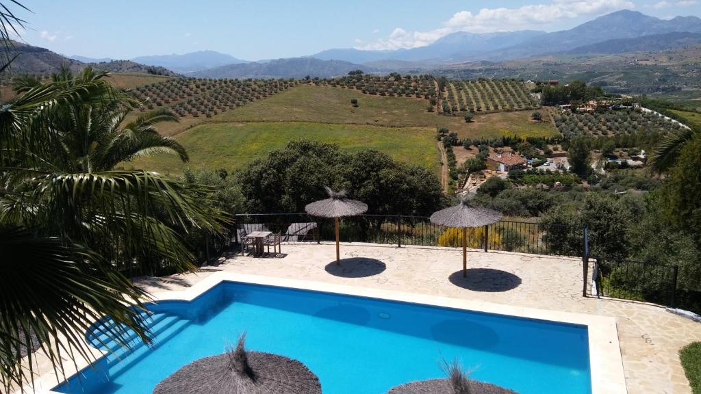 une villa avec une piscine et une vue sur la montagne dans l'établissement B&B Casa Domingo, à Alora