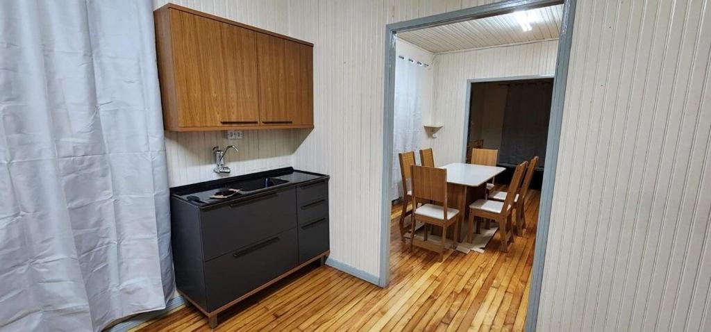 a kitchen with a sink and a table with a tableablish at Casa aconchegante e pratica in Cascavel