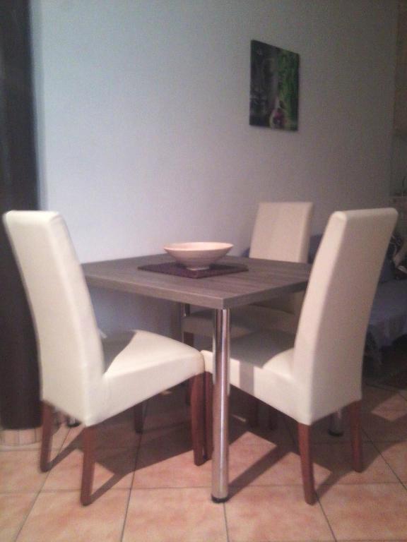 a wooden table with white chairs and a bowl on it at Apartments Eldi in Split