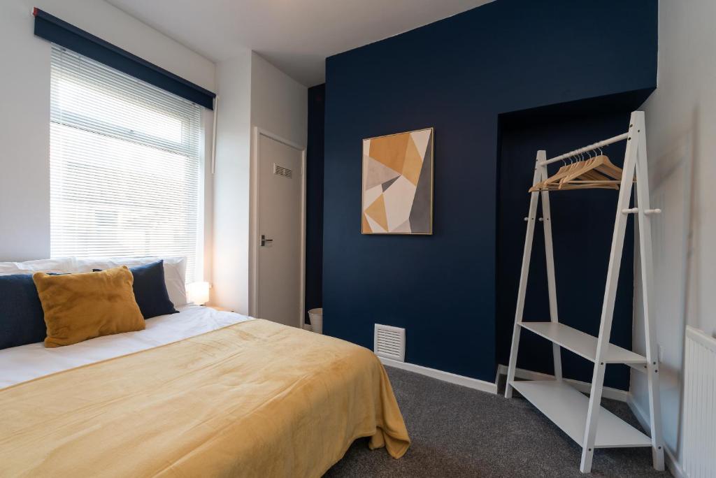 a bedroom with a blue wall with a bed and a ladder at Chic 3BR House in Hull - sleeps 5 in Hull