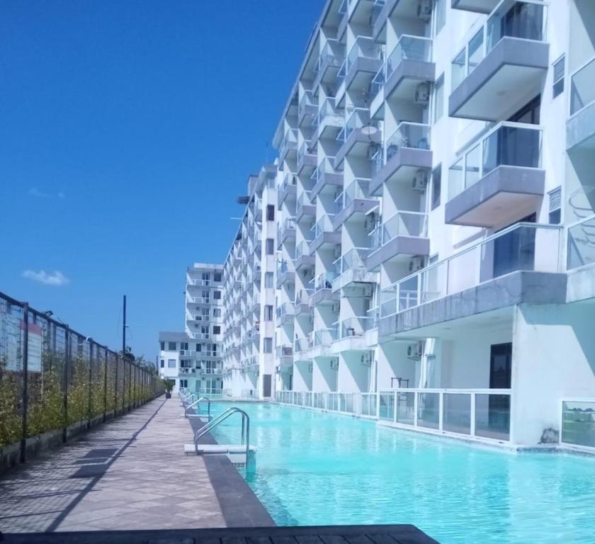 a building with a swimming pool next to a building at Paradise Room By Vivo Apartment in Seturan