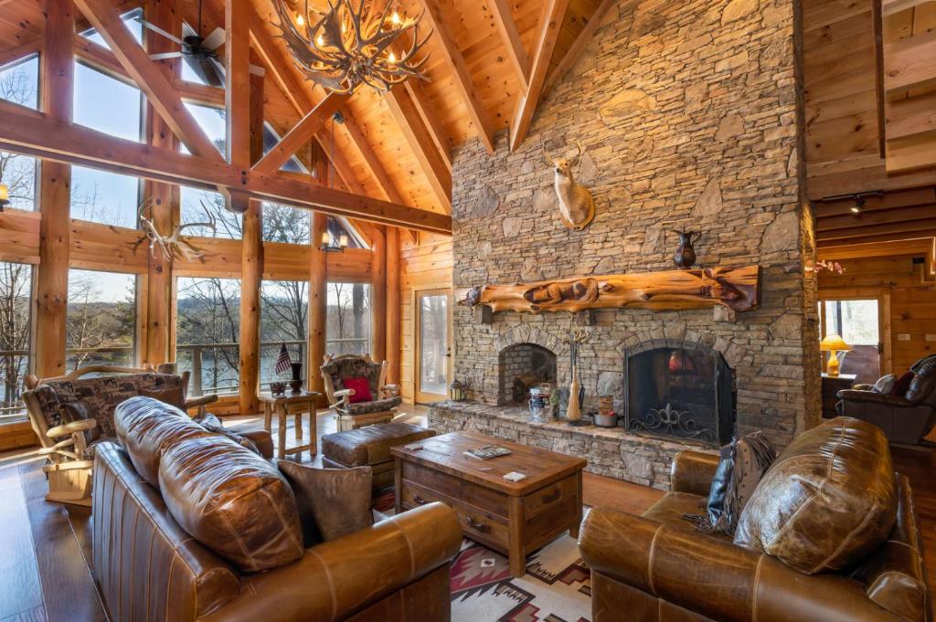 una gran sala de estar con chimenea de piedra. en Lake Haven Lodge, en Wilkesboro
