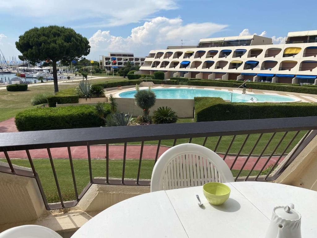 d'une table et de chaises sur un balcon avec piscine. dans l'établissement Studio 4 pers avec piscine et terrasse, Port Camargue - FR-1-250-167, au Grau-du-Roi