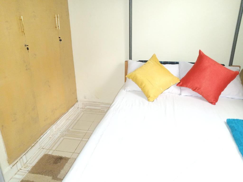 a bed with colorful pillows on it in a room at FonMark Haven in Webuye