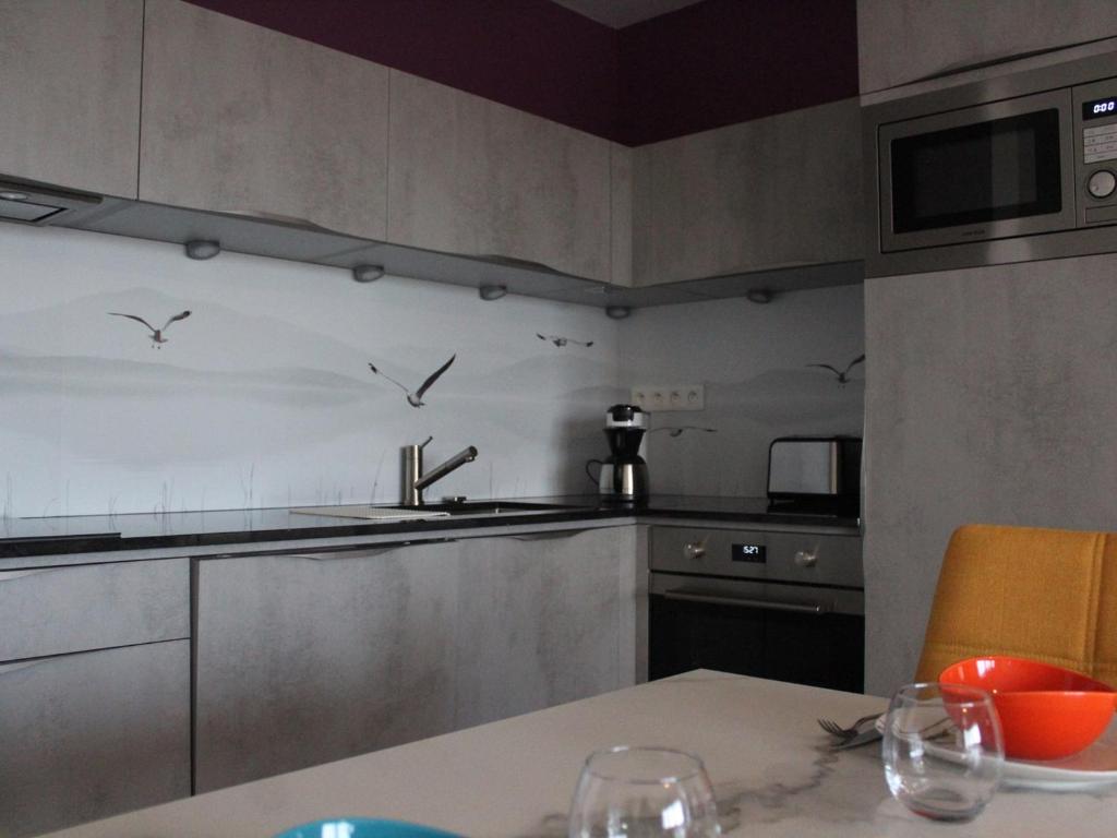 a kitchen with a table and a sink and birds on the wall at Appartement La Rochelle, 3 pièces, 4 personnes - FR-1-246-588 in La Rochelle
