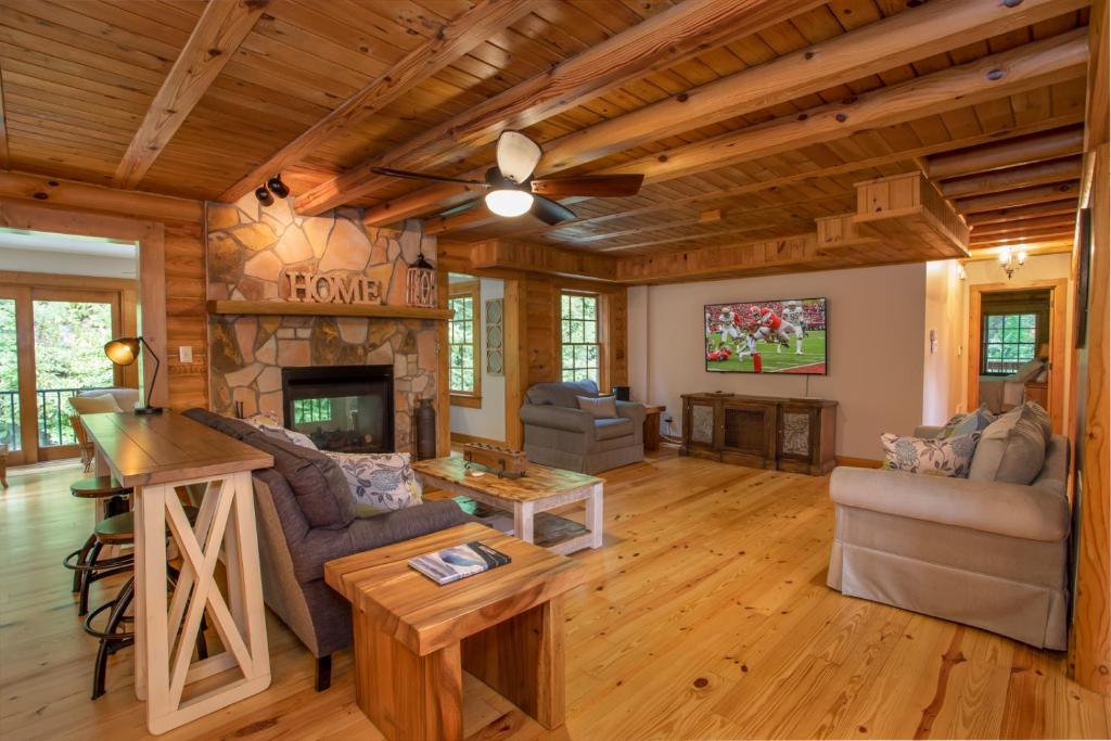 - un salon avec une cheminée dans une cabane en rondins dans l'établissement Mountainside Lodge, à Banner Elk