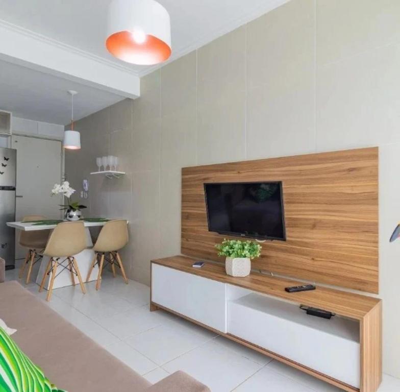 un salon avec une télévision à écran plat sur un mur dans l'établissement flatmaravilha, à Porto de Galinhas