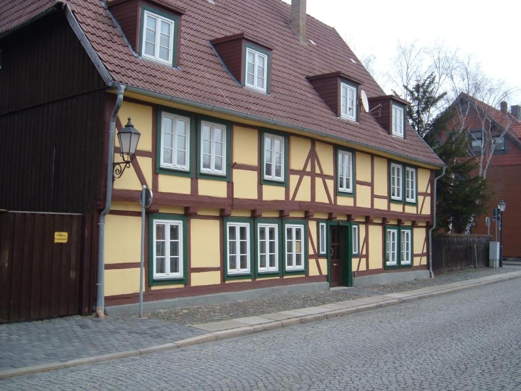 ein gelbes und braunes Gebäude mit rotem Dach in der Unterkunft Ferienwohnungen Pook in Wernigerode
