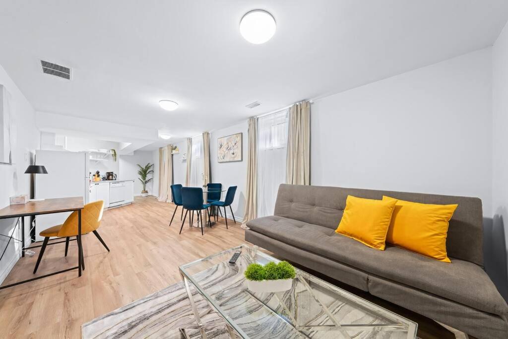 een woonkamer met een bank en een tafel met gele kussens bij Adorable 1-bdrm basement, Fast WIFI, Free Parking, Smart TV in Barrie