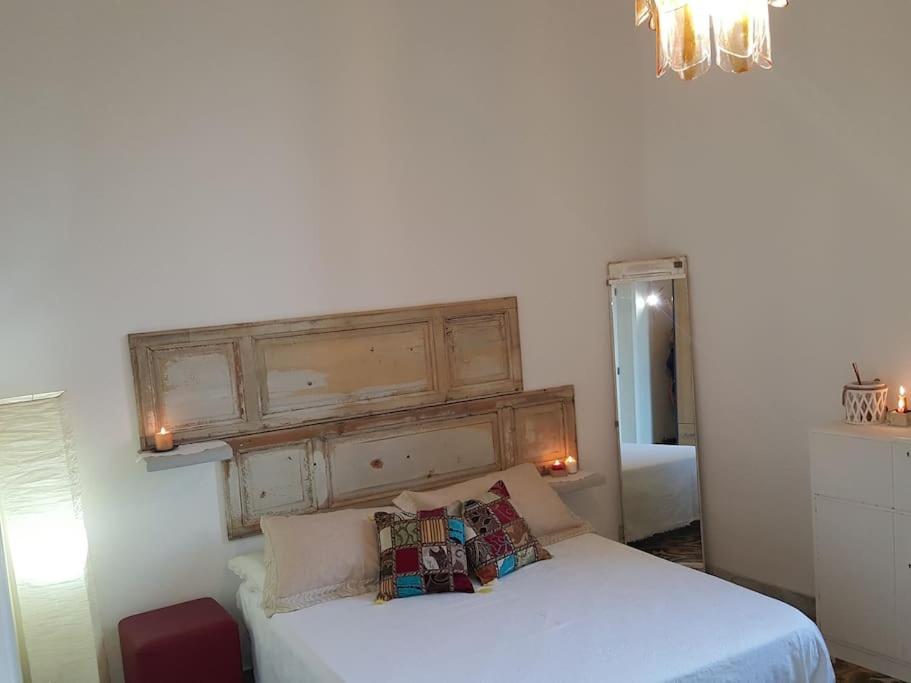 - une chambre avec un lit blanc et une tête de lit en bois dans l'établissement Signora Minù Bilocale Semindipendente, à Lecce