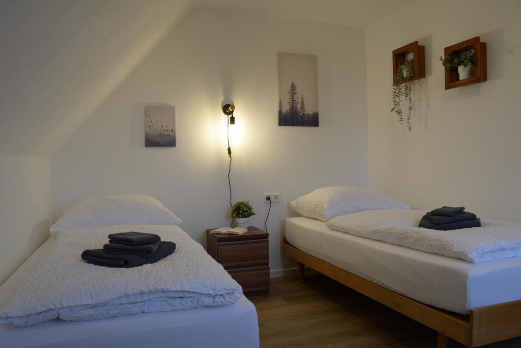 two beds in a bedroom with two towels on them at Privatzimmer im Einfamilienhaus in Emden