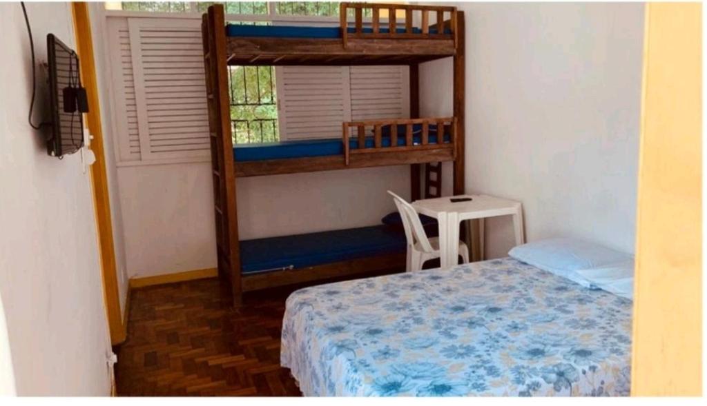 um quarto com 2 beliches e uma mesa em Lord Hostel Salvador BA em Salvador